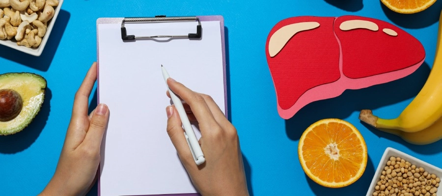 uma pessoa escrevendo cercada por frutas e nozes e uma ilustração de fígado