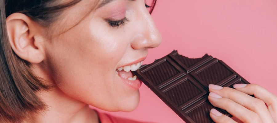 Mulher matando a vontade de comer doce com um chocolate