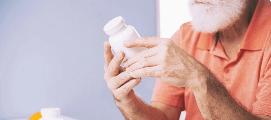 homem segura um frasco de suplemento e lê o rótulo atentamente