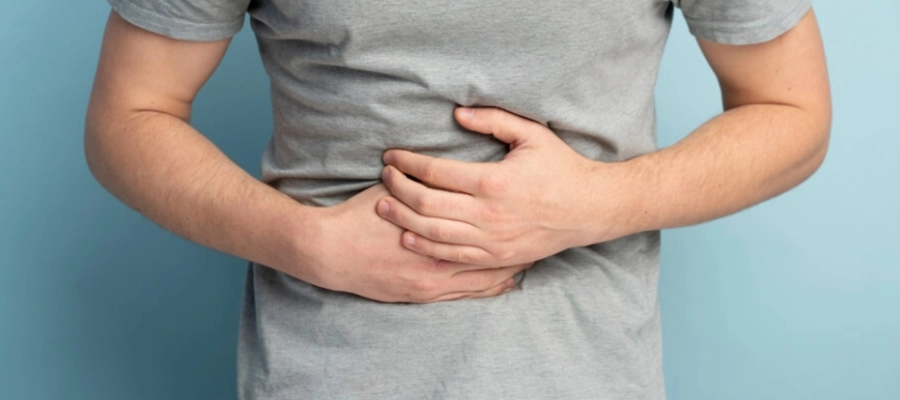 homem com dor de estômago e as mãos sobre a barriga.